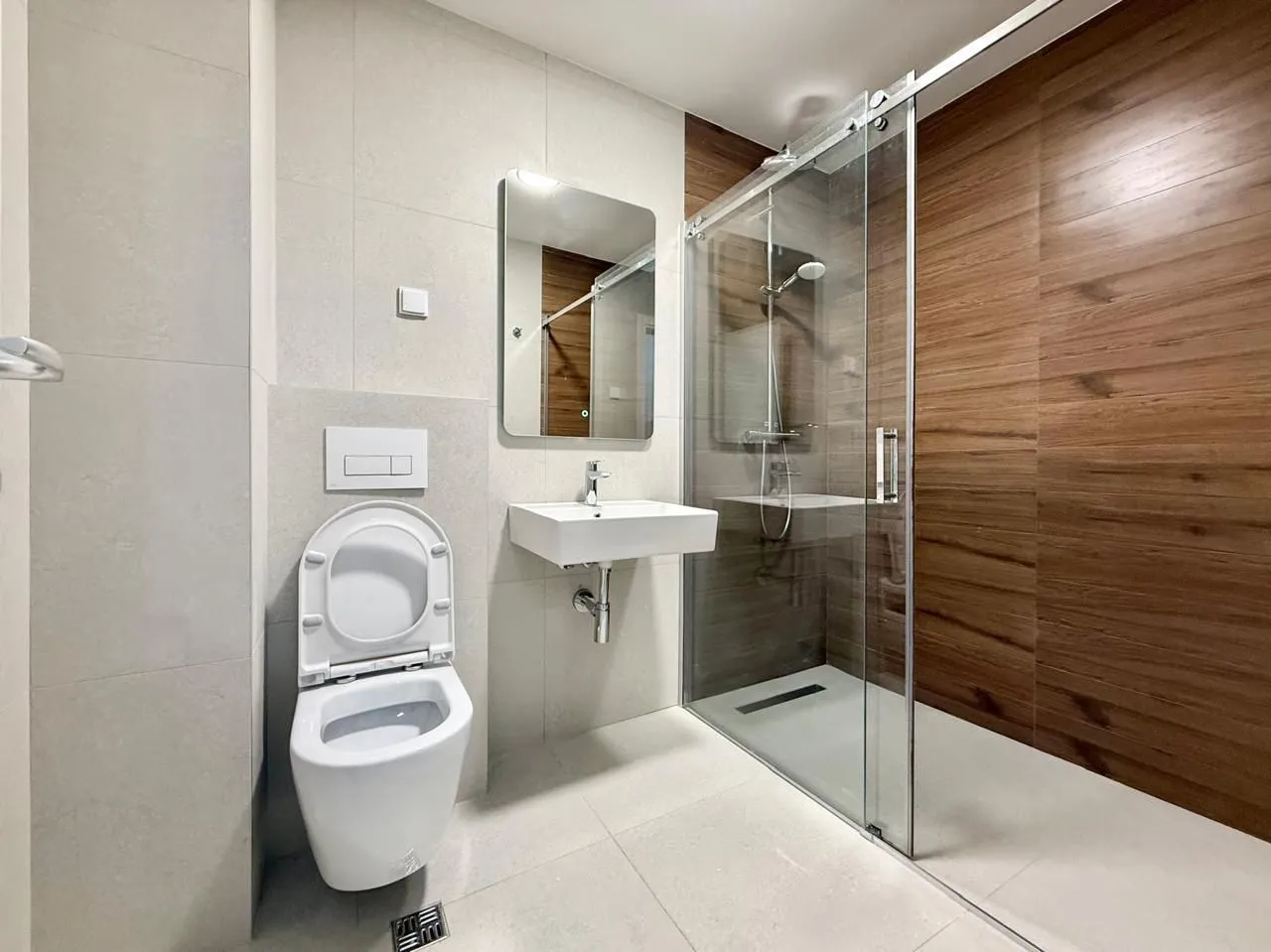 Moderne opremljeno kupatilo sa tuš kabinom i bijelim sanitarijama.