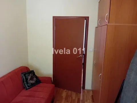 Manja soba sa crvenim kaučem i drvenim ormanom. - image 12