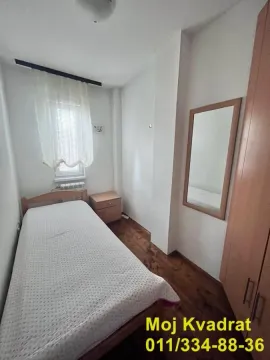 Manja spavaća soba sa krevetom, ormarom i prozorom. - image 14