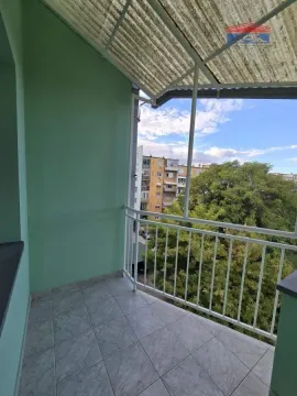 Natkriveni balkon sa popločanim podom i pogledom na okolne zgrade i zelenilo. - image 13