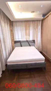 Spavaća soba sa bračnim krevetom, plakarom i prozorima sa zavesama. - image 6
