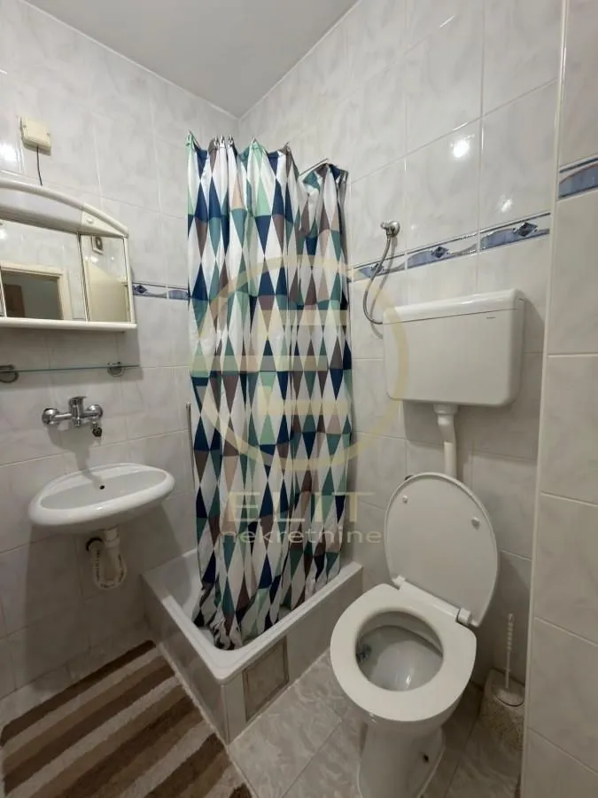 Manje kupatilo sa tuš kabinom, umivaonikom i toaletom.