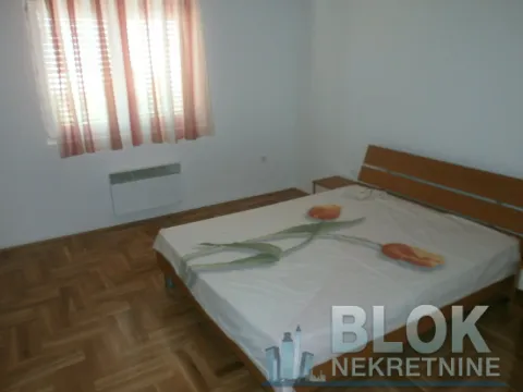 Bedroom with a double bed, wooden parquet flooring, and a window with curtains. - image 14