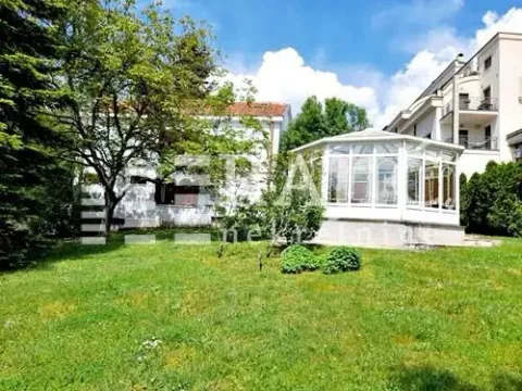 View of the yard and the house with a glass conservatory. - image 2