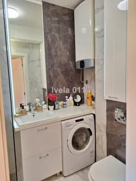 Kupatilo opremljeno umivaonikom, veš mašinom i toaletom. - image 8