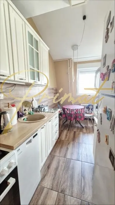 Smaller kitchen with white cabinetry and a dining table in the corner.