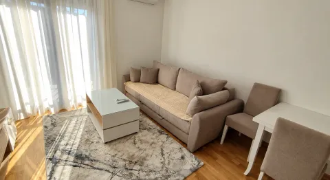 Living room with a beige sofa, coffee table, and dining table. - image 8