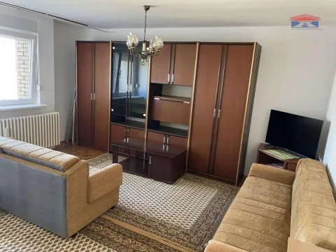 Dnevna soba sa garniturom za sedenje, velikim drvenim ormanom i televizorom. - image 2