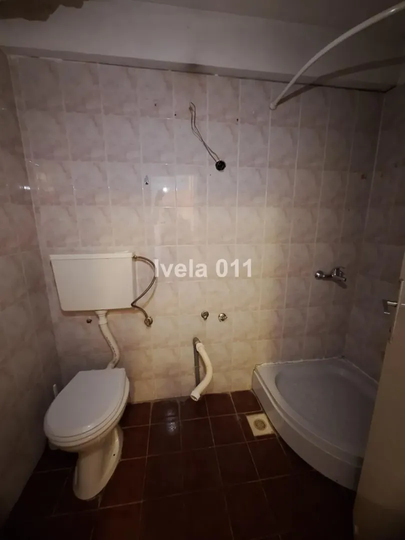 Small tiled bathroom with a shower cabin and sanitary ware.