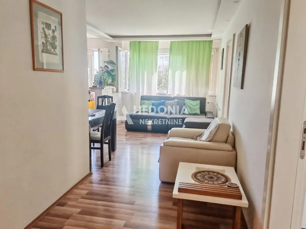 Dnevna soba sa garniturom i trpezarijskim delom.