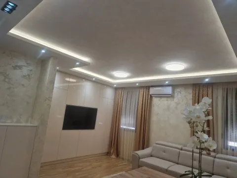 Svijetla dnevna soba sa spuštenim plafonom, ugradnim televizorom i kožnom garniturom. - image 5