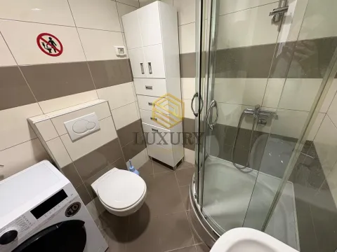 Small bathroom with a shower cabin, toilet, and white cabinetry. - image 8