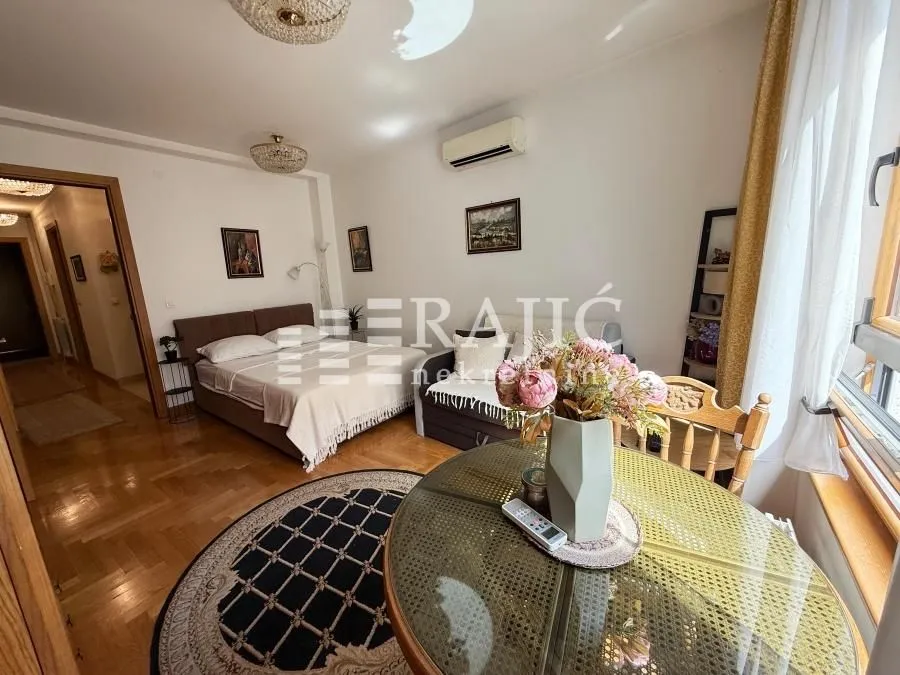Spacious bedroom with a bed and dining table.