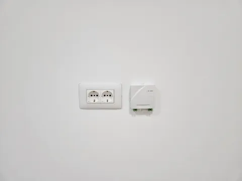 White wall with electrical outlet and telecommunication socket. - image 11