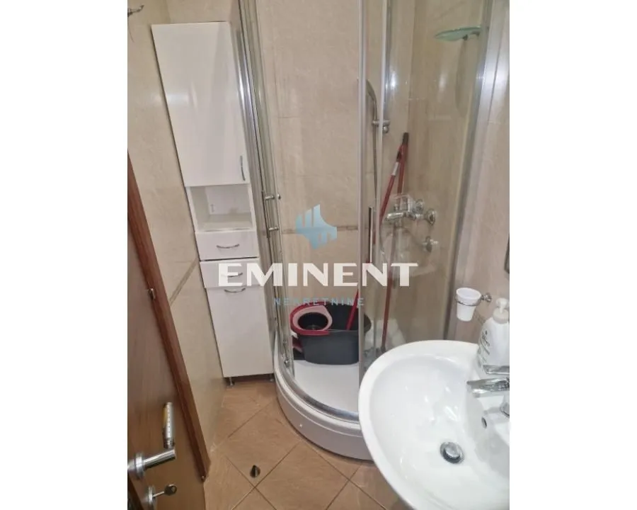 View of the bathroom with a shower cabin and a washbasin.
