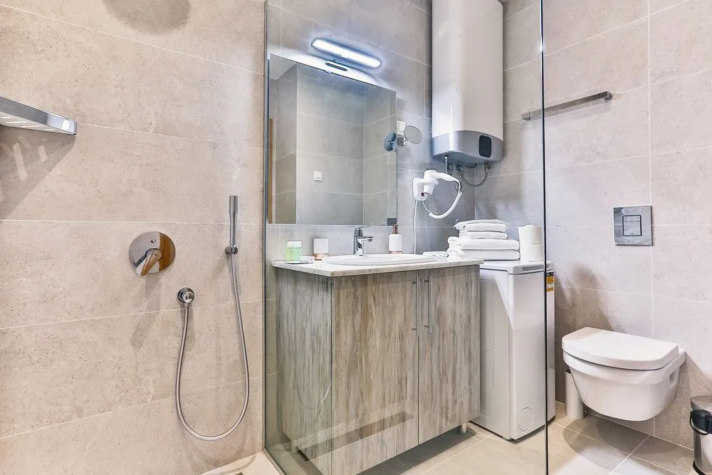 Modern bathroom with a walk-in shower, washbasin, and toilet.
