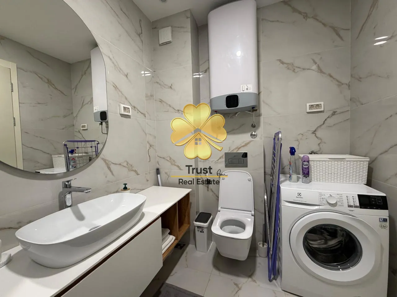 Modernly equipped bathroom with a washbasin, toilet, and washing machine.