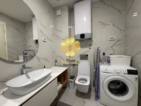 Modernly equipped bathroom with a washbasin, toilet, and washing machine. - image 9