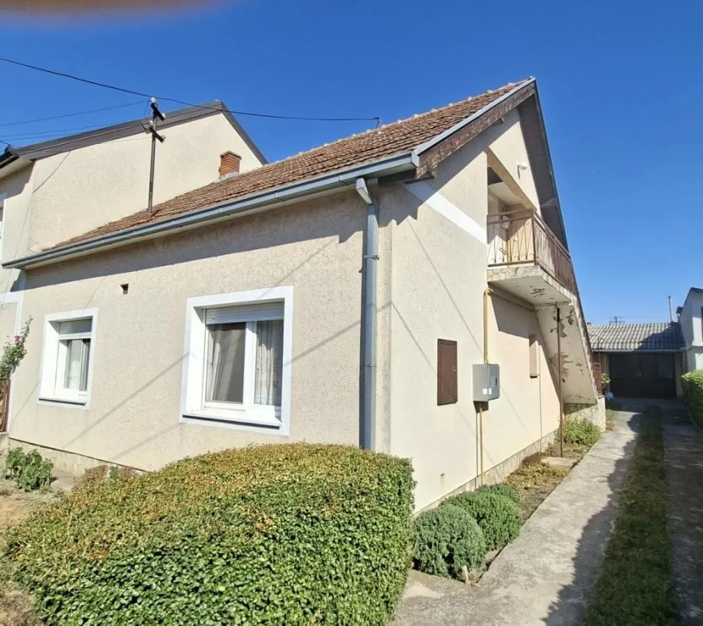 Pogled na spoljašnjost kuće sa dvorištem i stazom.