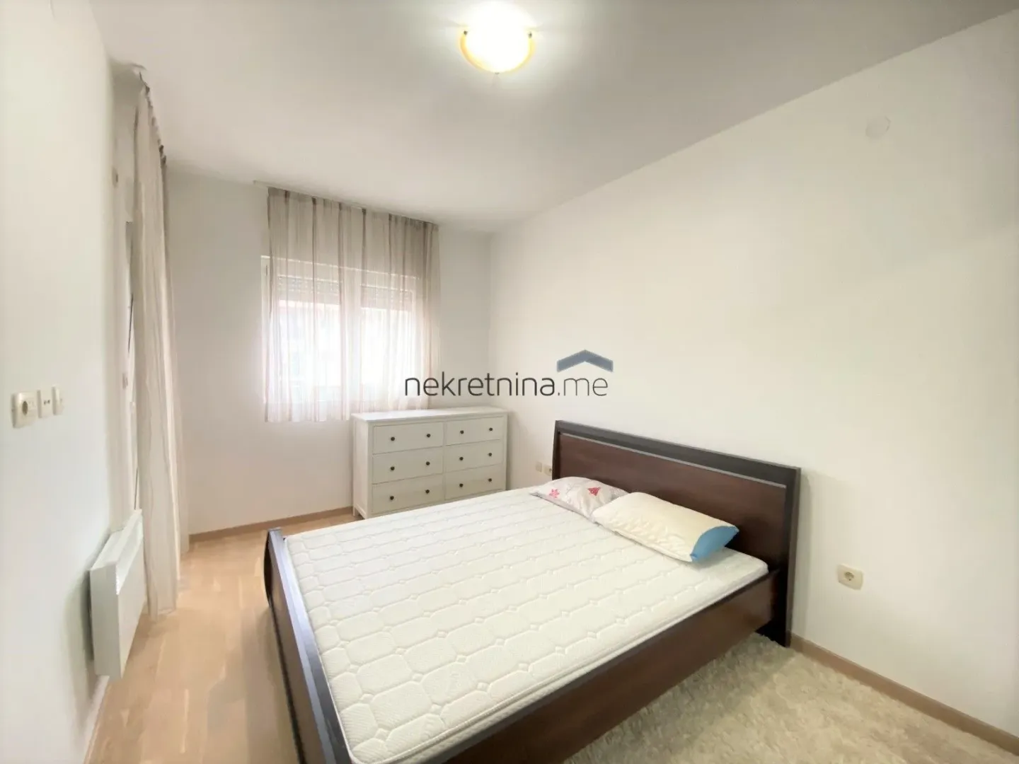 Bright bedroom with a double bed and dresser.