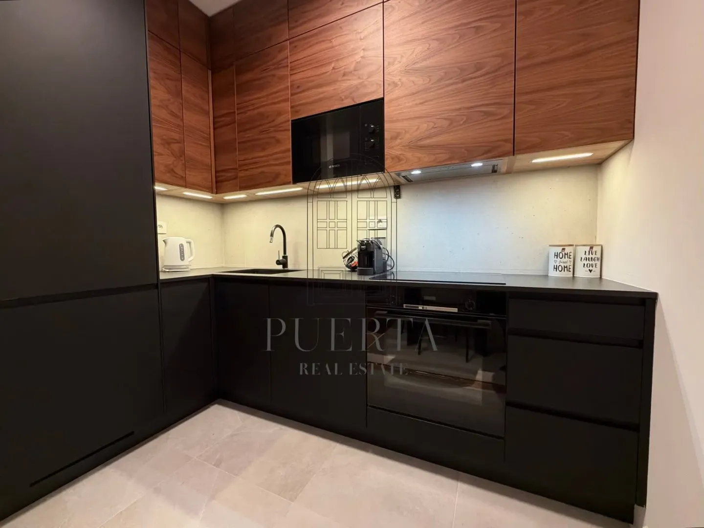 Modern kitchen with dark cabinetry and wooden upper cabinets.