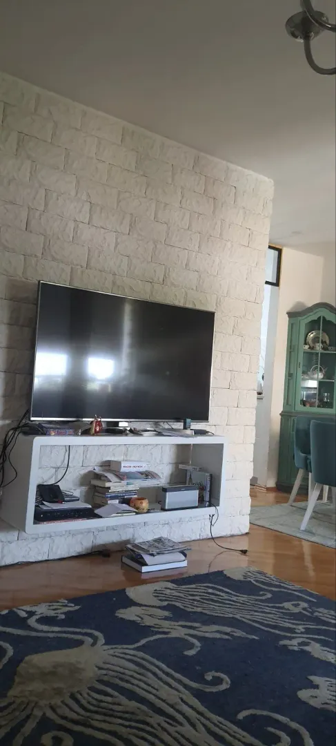 Living room featuring a decorative stone wall and a television.