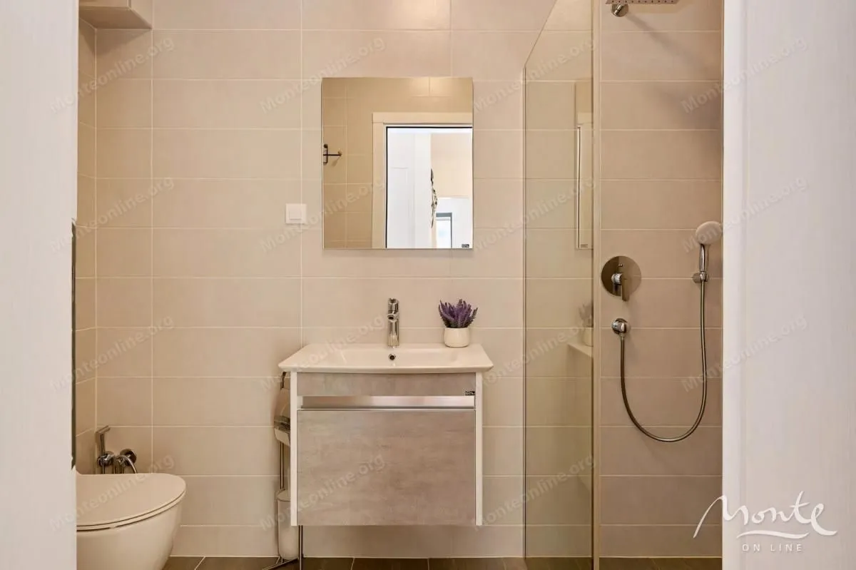 Moderne kupatilo sa tuš kabinom, umivaonikom i WC šoljom.