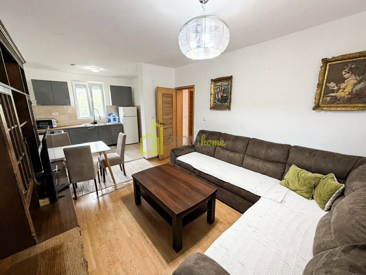 Living room with sofa and dining area connected to the kitchen.