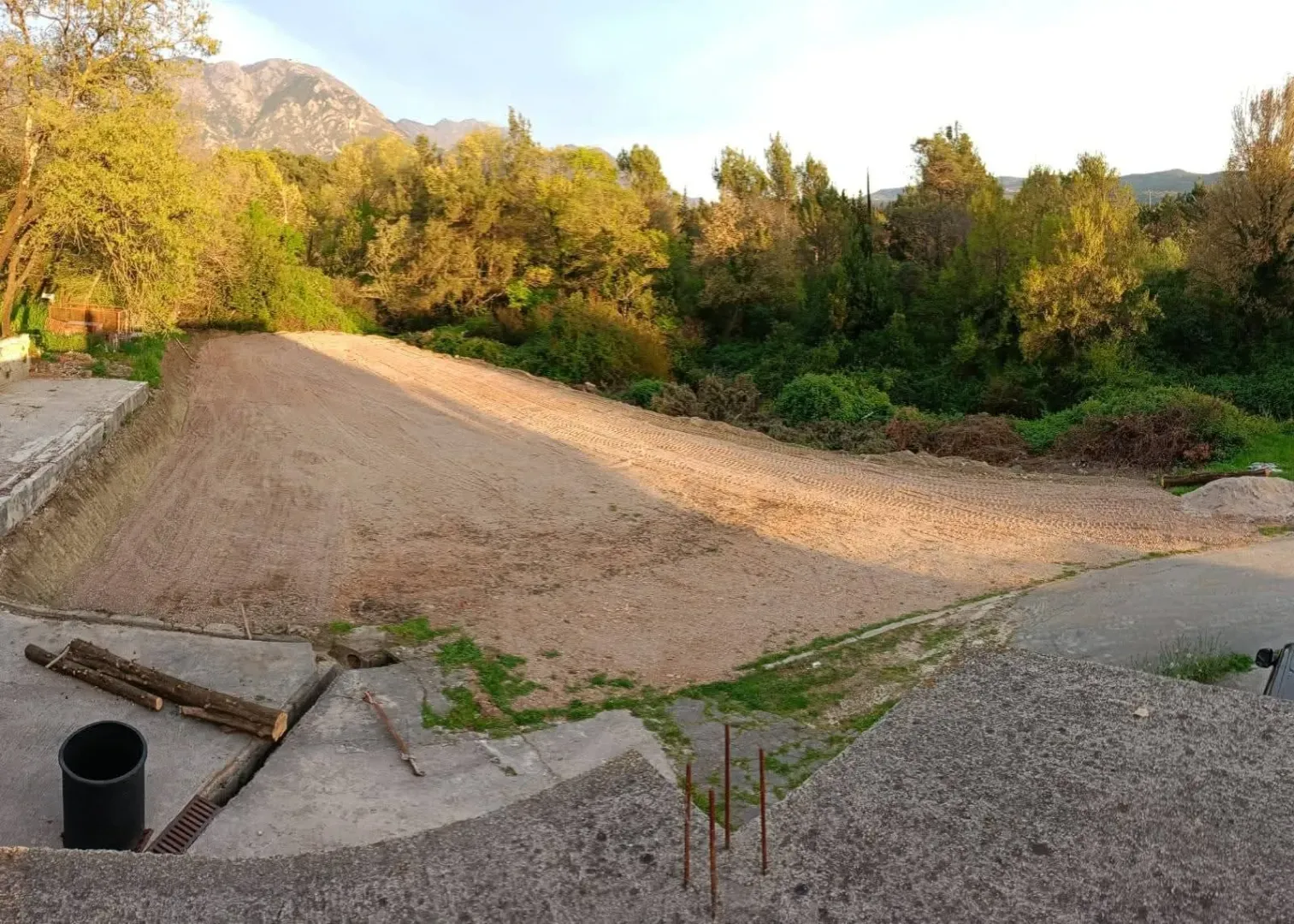 Land prepared for construction with a view of the forest and mountains.