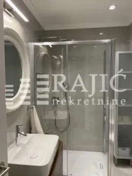 Modernly equipped bathroom with a shower cabin and a sink. - image 4