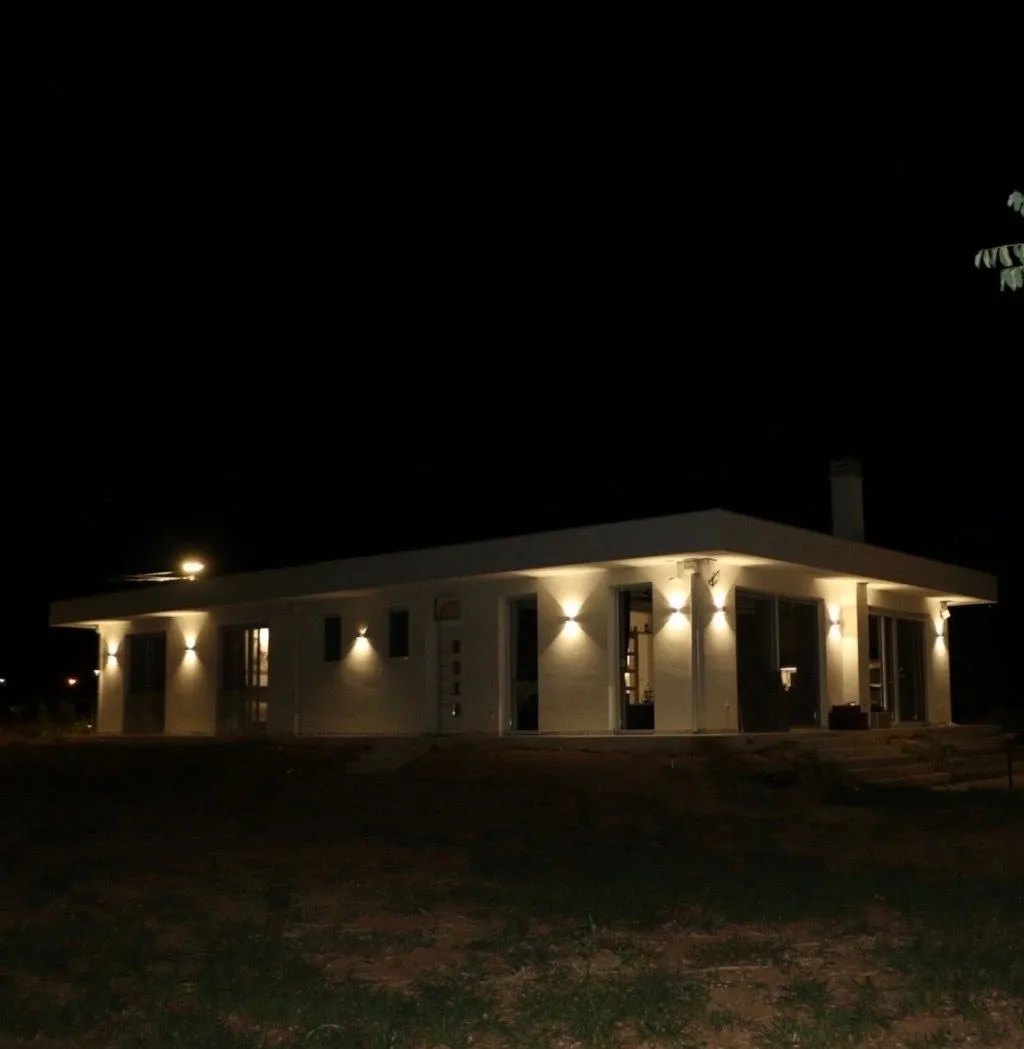 Night view of a modern single-story house with exterior lighting.