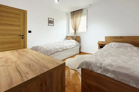Spavaća soba sa dva odvojena kreveta i drvenim namještajem. - image 12