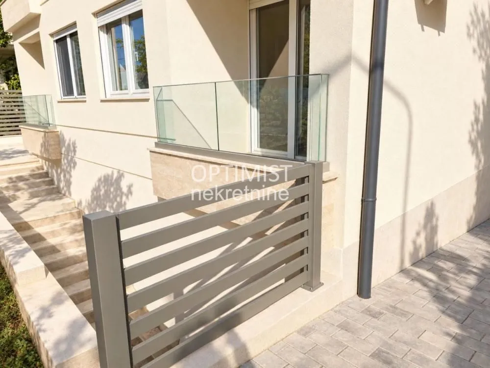 View of the exterior of the building with stairs and a balcony.