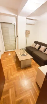 Living room with sofa, coffee table, and parquet flooring. - image 3