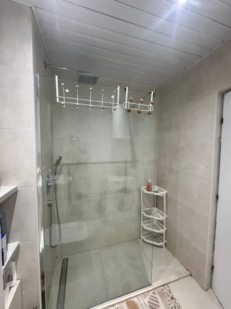 Modern bathroom with a shower cabin and ceramic tiles.