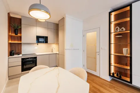 Modern kitchen with built-in appliances and a dining table. - image 5