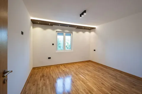 Empty room with hardwood flooring and recessed ceiling lighting. - image 7