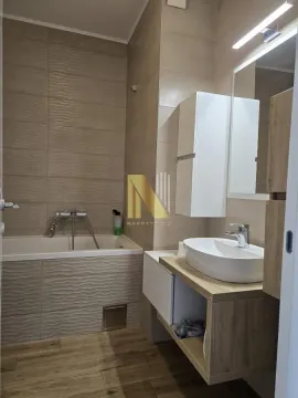 Modernly equipped bathroom with a bathtub and a washbasin. - image 8