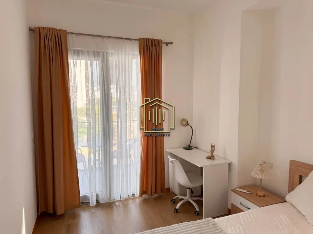 Furnished bedroom with a desk and access to a balcony.