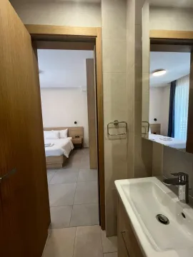 Pogled iz kupatila prema spavaćoj sobi u modernom stanu. - image 11
