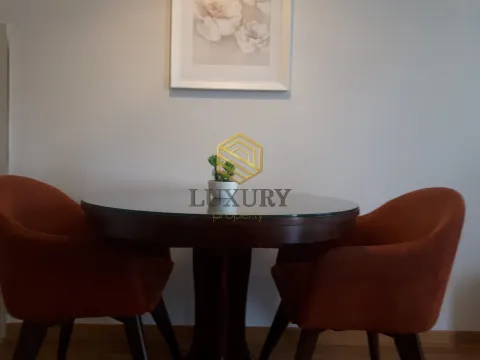 Okrugli sto sa dvije narandžaste fotelje u enterijeru. - image 3