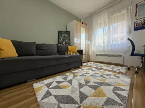 Dnevna soba sa garniturom za sedenje, ormarom i prozorom sa belim zavesama. - image 14