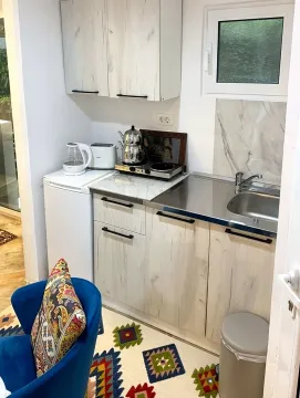 Manja čajna kuhinja sa bijelim elementima, sudoperom i radnom pločom. - image 6