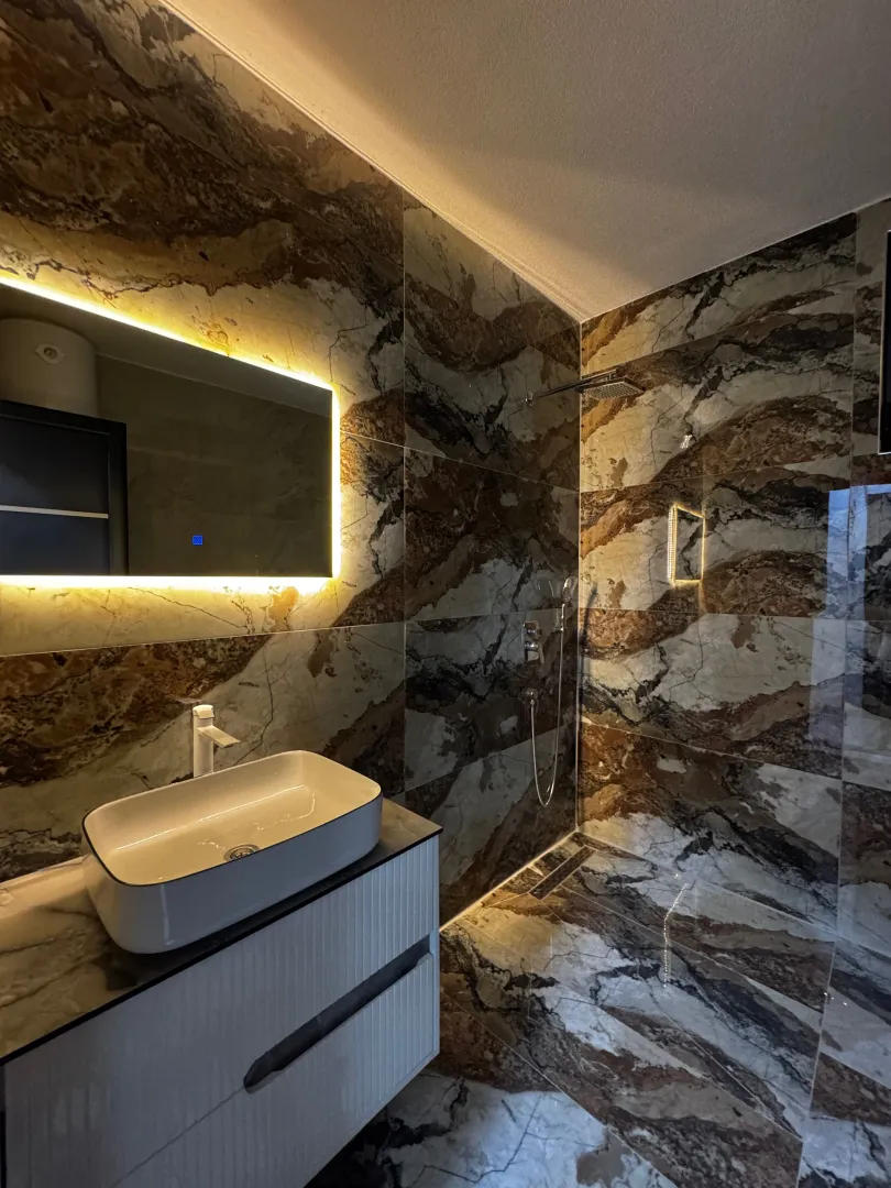 Modern bathroom with a basin and a walk-in shower.