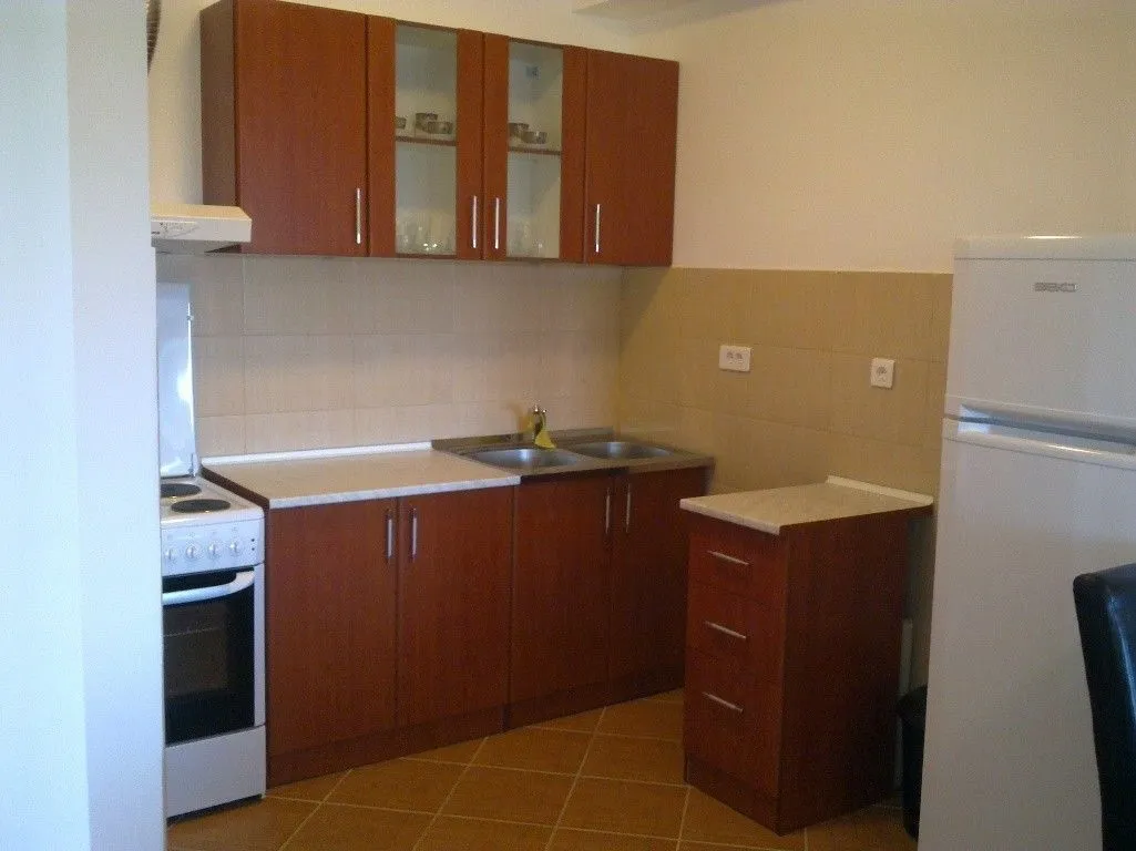Simple kitchen with wooden cabinets and white appliances.
