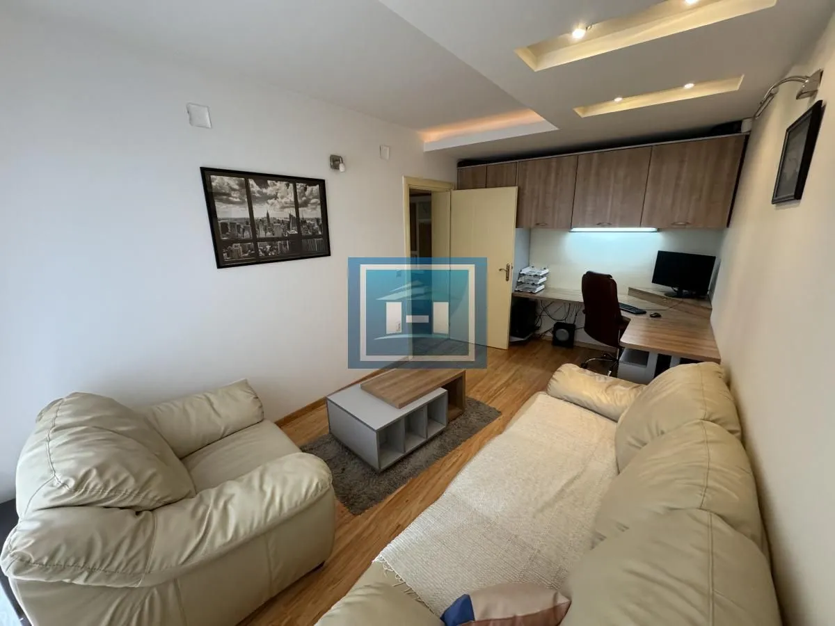 Living room with sofa set, coffee table, and a desk against the wall.