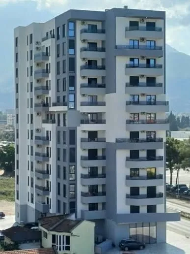 View of a modern multi-story residential building with balconies.