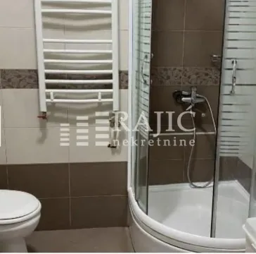Smaller bathroom with a shower cabin, toilet, and towel radiator. - image 8