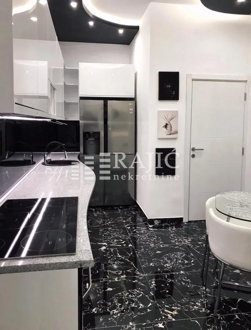 Modern kitchen with black flooring and white cabinetry.