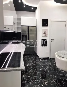 Modern kitchen with black flooring and white cabinetry. - image 6